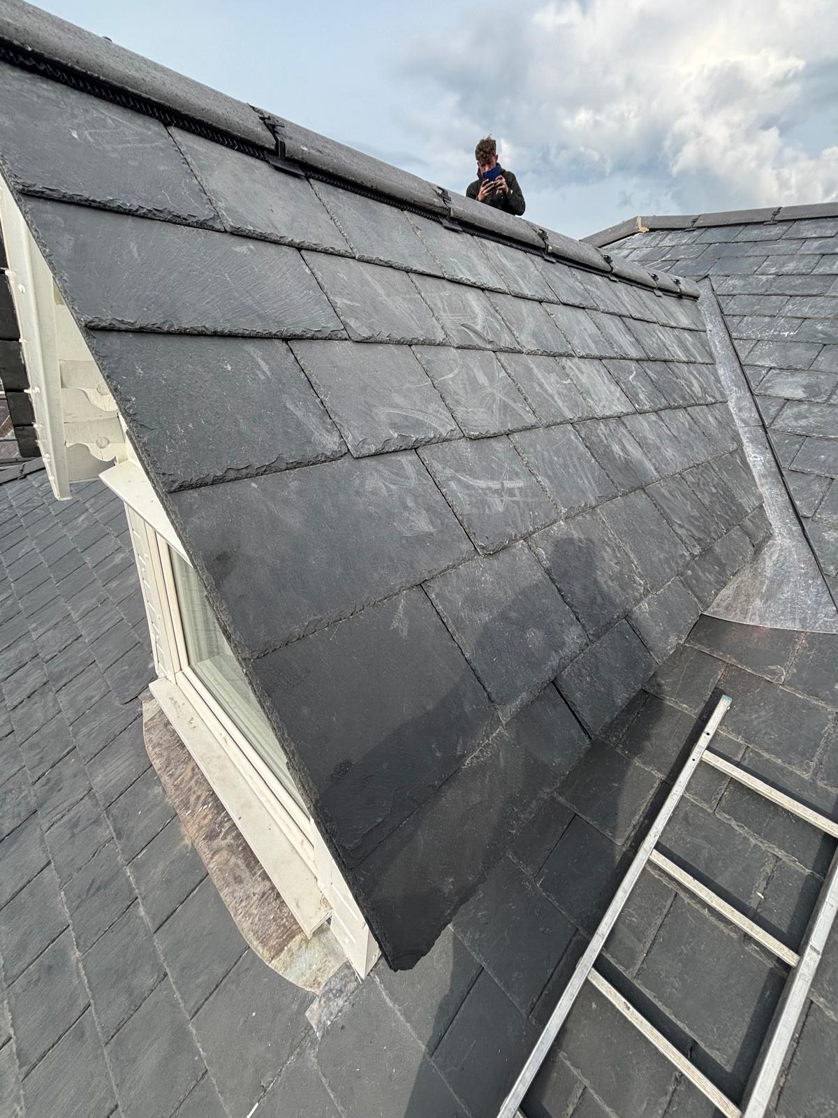 Completed natural slate roof with neat ridge tiles and lead detailing