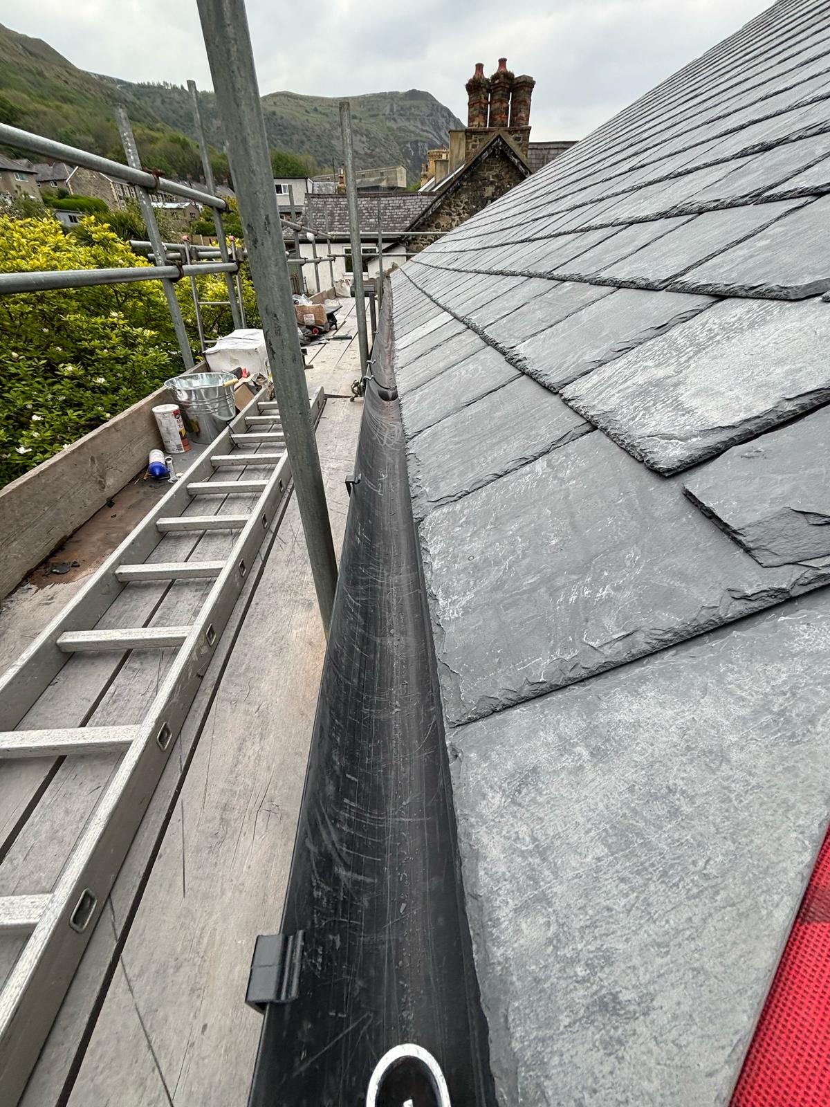 Completed natural slate roof with neat ridge tiles and lead detailing