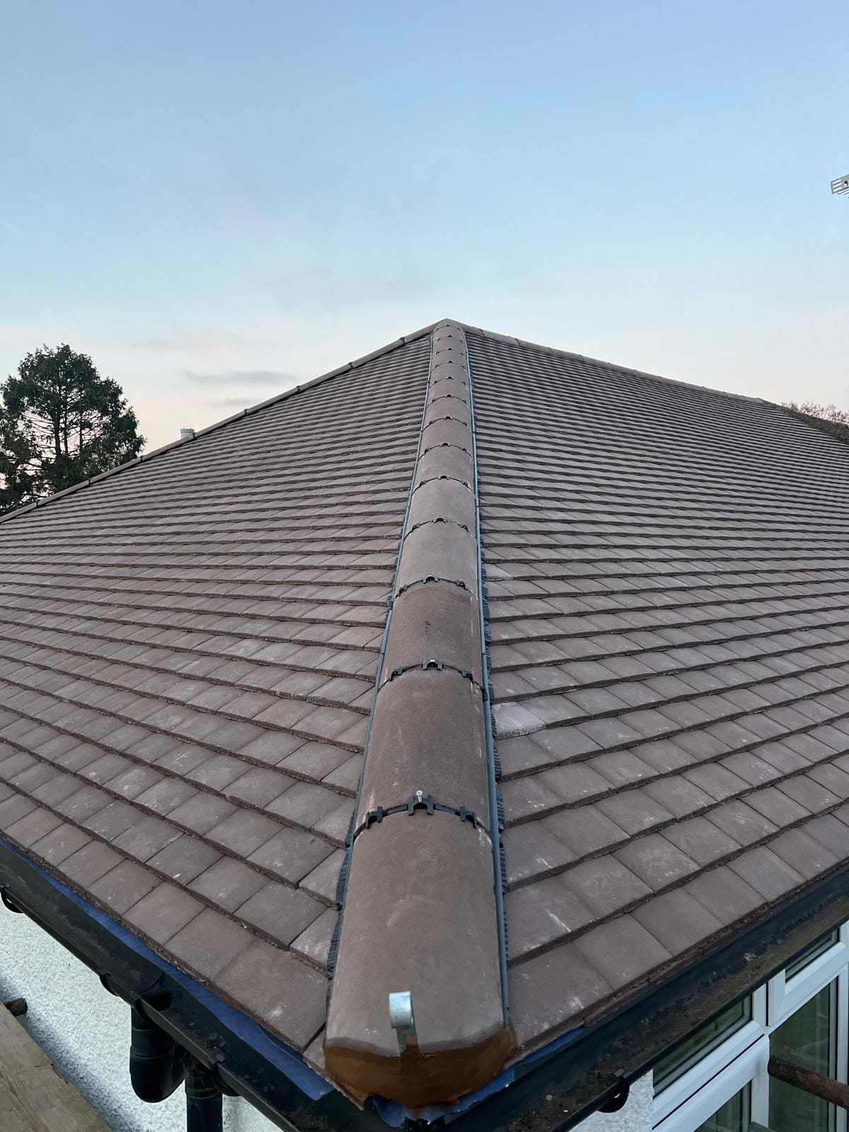 Completed tiled roof with new ridge tiles and guttering in North Wales